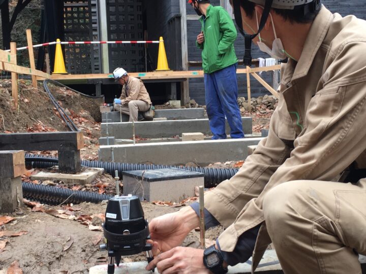 基礎の高さと土台の芯のチェック。手前のレーザーがあたると奥の赤いランプが青く光ります