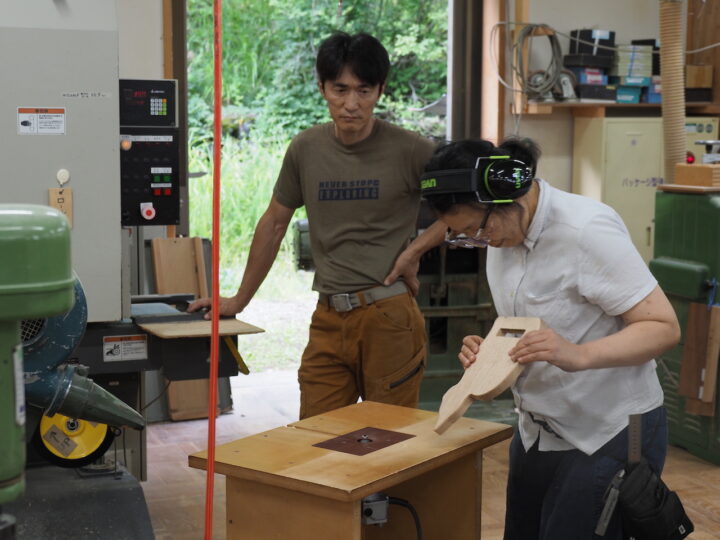 森林文化アカデミーの学生(手前)の作業を見守る飛騨職人学舎の教員、玉田義卓さん。
