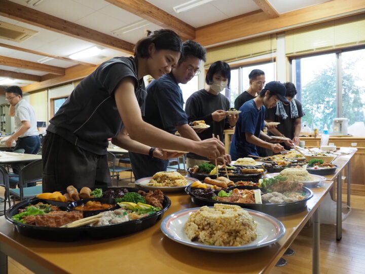 懇親会で食事を盛る学生